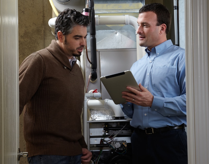 An HVAC technician talking with a client