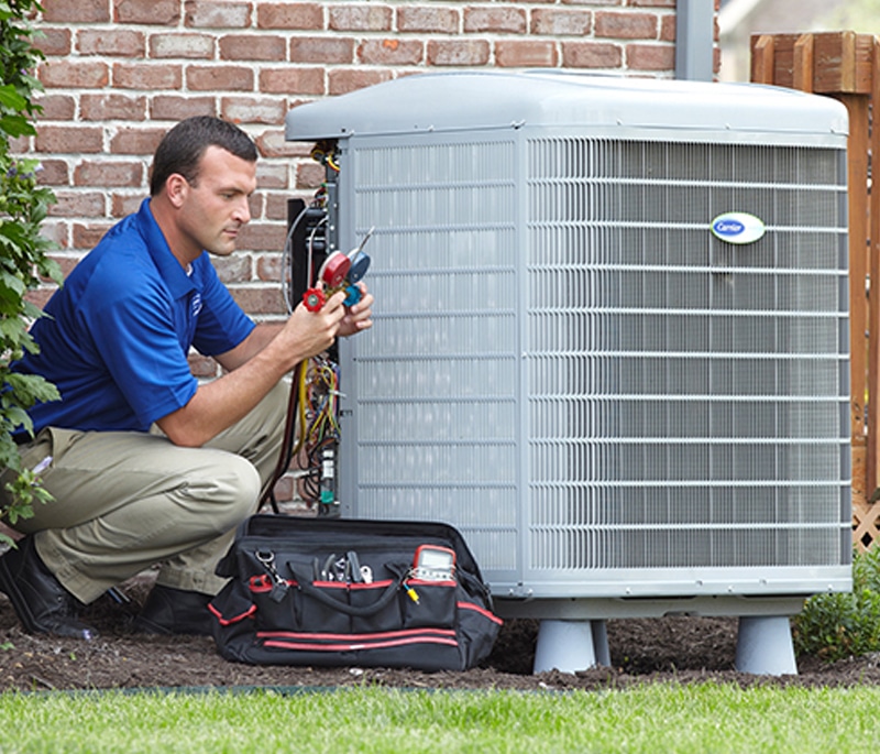 An HVAC technician repairing a large AC unit