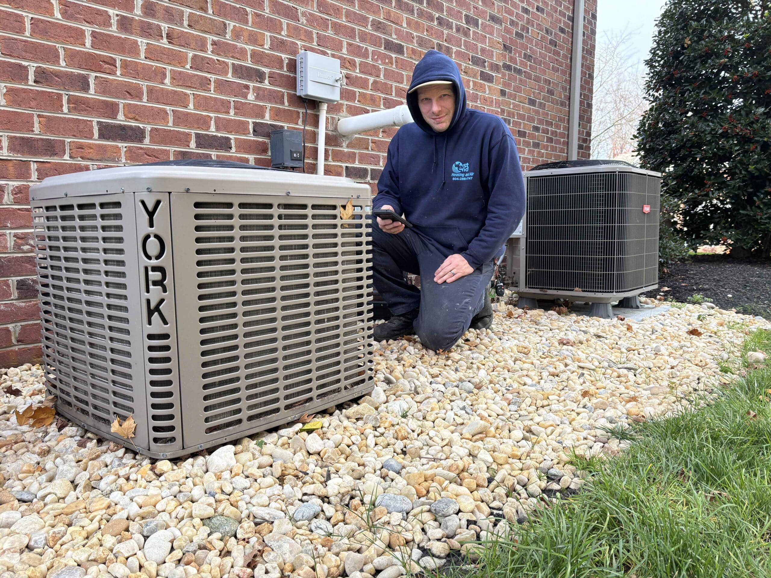 a man standing next to outdoor HVAC system