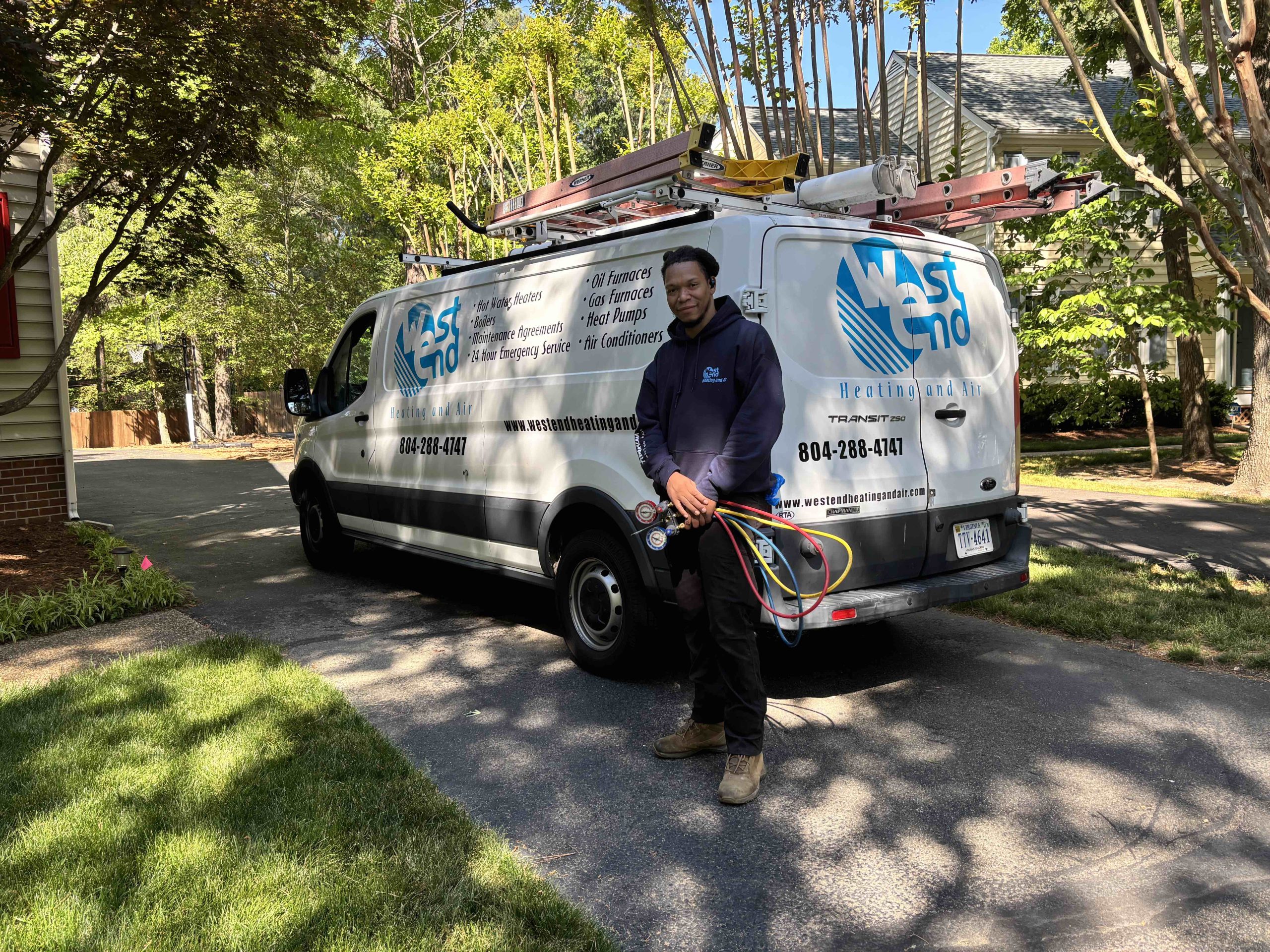 Man in front of work van holding air conditioning gauges
